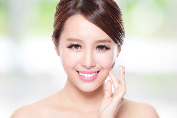 young woman touching her cheek with her finger