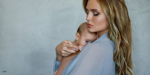 Mother holding her baby on blue background